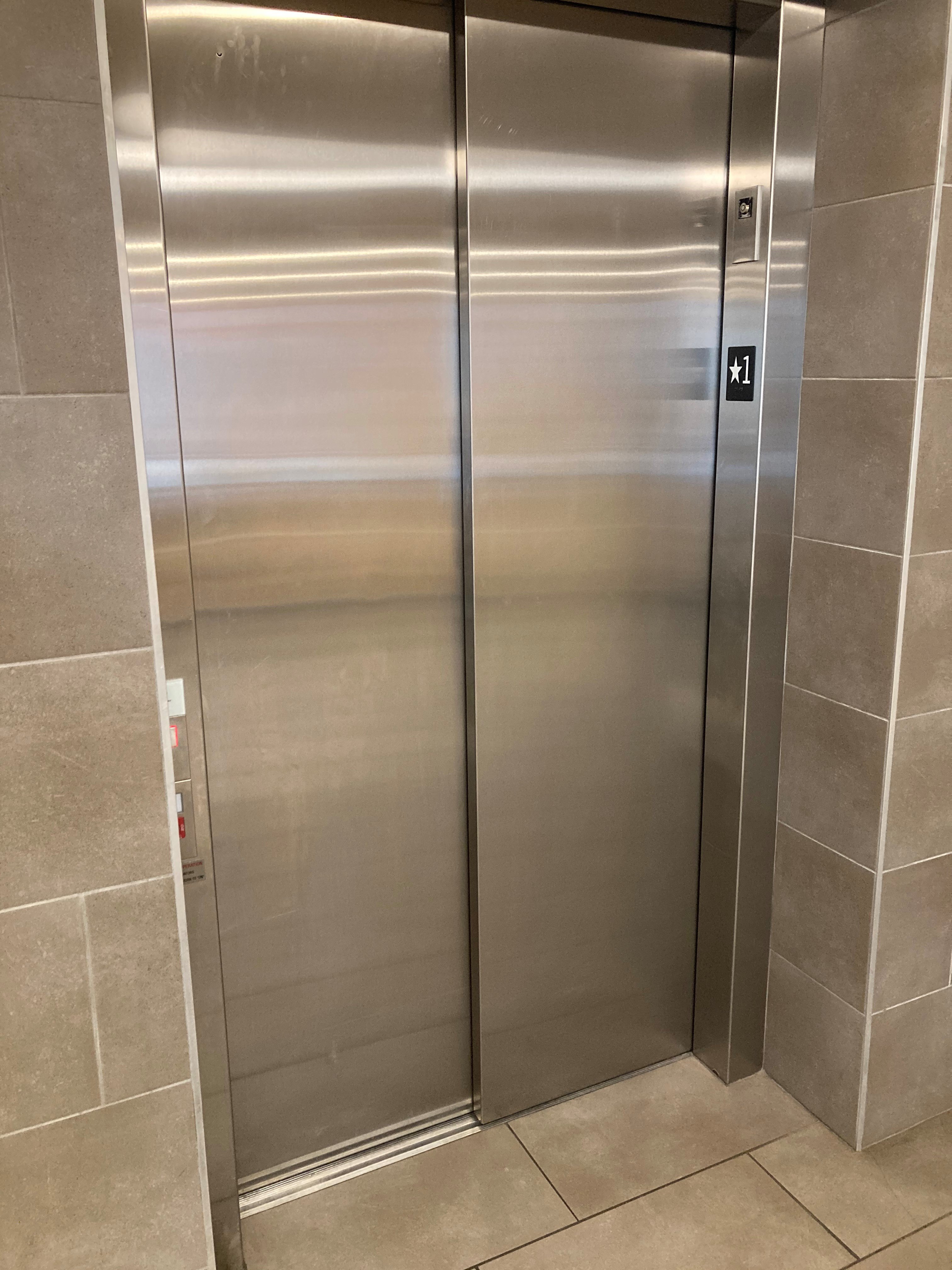 a large stainless steel elevator in a bathroom